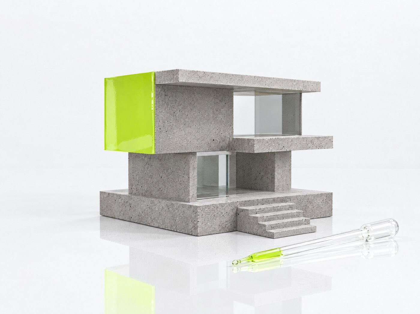 Maqueta de una casa de concreto con una fachada recubierta de material verde y una pipeta de vidrio.